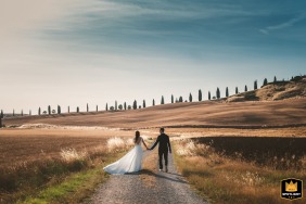 In the breathtaking rolling landscape of Crete Senesi, Tuscany, the newly married couple is captured in a beautiful and romantic formal portrait amidst the iconic Italian countryside.